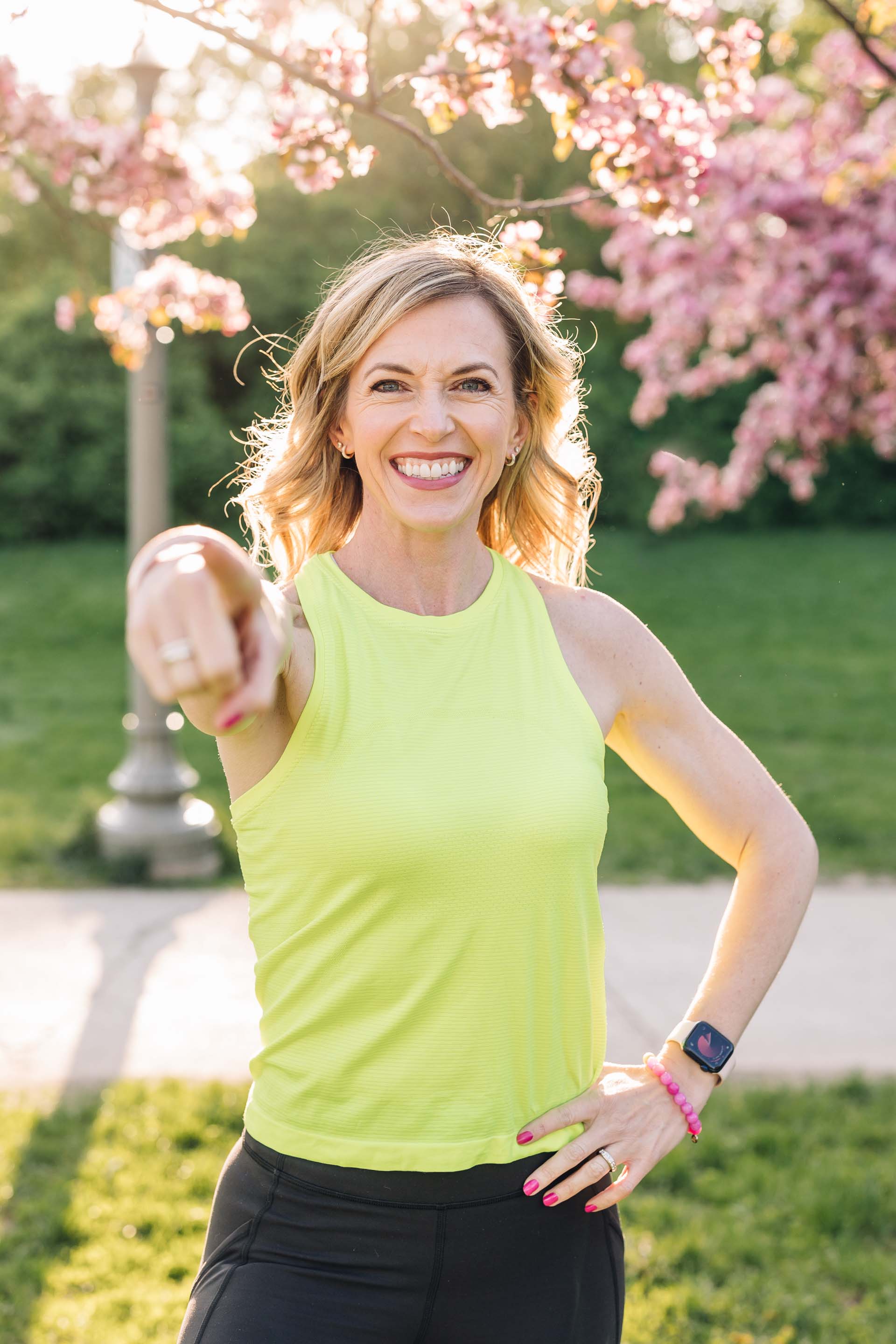 Personal trainer Meryl Marciante smiling while skipping rope in a white tank top and pink leggings.
